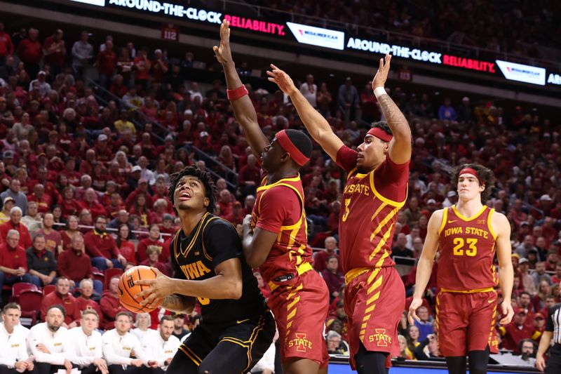 Dec 11, 2025; Ames, Iowa, USA;  Iowa Hawkeyes guard Tavion Banks (6) looks for the opening against Iowa State Cyclones guard Killyan Toure (27) and Iowa State Cyclones guard Tamin Lipsey (3) during the second half at James H. Hilton Coliseum. Mandatory Credit: Reese Strickland-Imagn Images