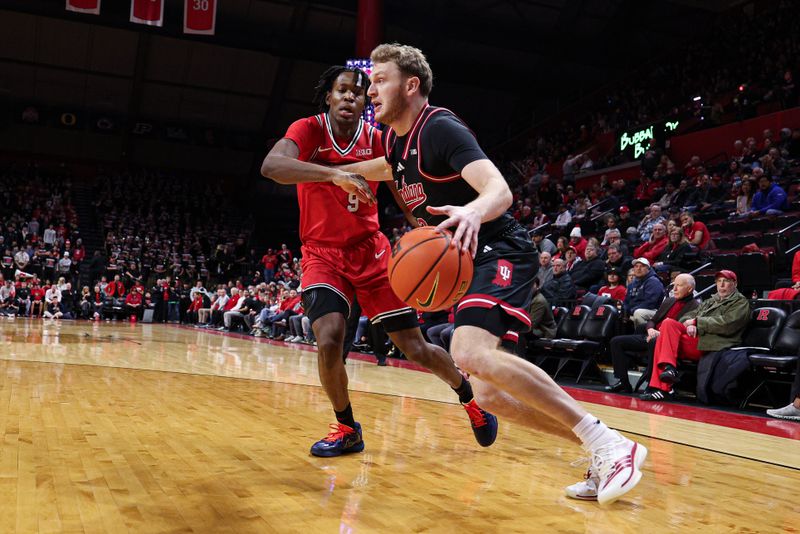 Jan 23, 2026; Piscataway, New Jersey, USA; Indiana Hoosiers forward Tucker Devries (12) drives to the basket against Rutgers Scarlet Knights forward Dylan Grant (9) during the first half at Jersey Mike's Arena. Mandatory Credit: Vincent Carchietta-Imagn Images