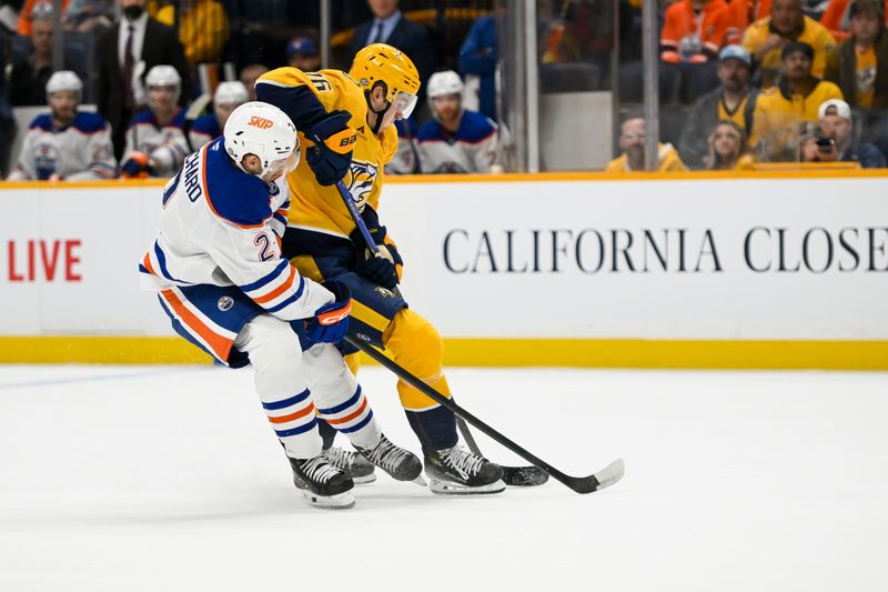 Oct 17, 2024; Nashville, Tennessee, USA;  Edmonton Oilers defenseman Brett Kulak (27) and Nashville Predators defenseman Brady Skjei (76) fight for the puck during the first period at Bridgestone Arena. Mandatory Credit: Steve Roberts-Imagn Images