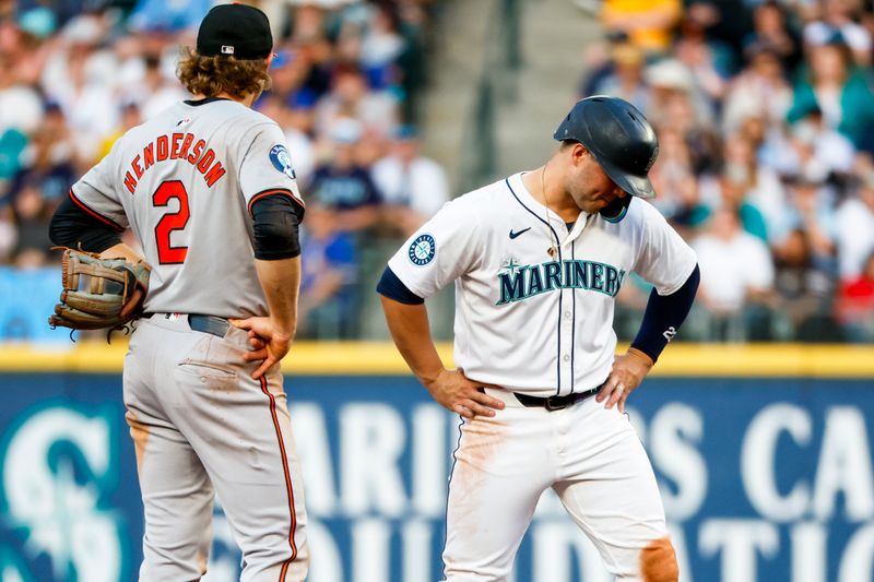 Jul 2, 2024; Seattle, Washington, USA; Seattle Mariners first baseman Ty France (23) reacts following a video review overturning a safe call against the Baltimore Orioles during the sixth inning at T-Mobile Park. Baltimore Orioles shortstop Gunnar Henderson (2) stands at left. Mandatory Credit: Joe Nicholson-USA TODAY Sports