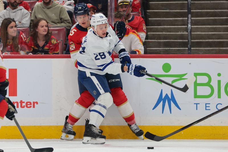 Dec 2, 2025; Sunrise, Florida, USA; Toronto Maple Leafs defenseman Troy Stecher (28) moves the puck against Florida Panthers center Anton Lundell (15) during the first period at Amerant Bank Arena. Mandatory Credit: Sam Navarro-Imagn Images