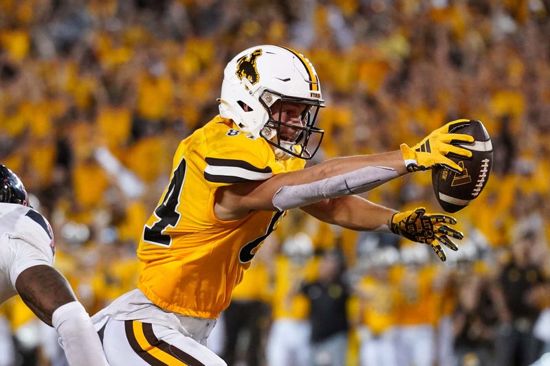 Sep 2, 2023; Laramie, Wyoming, USA; Wyoming Cowboys tight end John Michael Gyllenborg (84) scores a touchdown in double overtime against the Texas Tech Red Raiders at Jonah Field at War Memorial Stadium. Mandatory Credit: Troy Babbitt-USA TODAY Sports