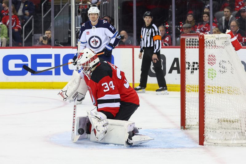 Mar 21, 2024; Newark, New Jersey, USA; New Jersey Devils goaltender Jake Allen (34) makes a save against the Winnipeg Jets during the first period at Prudential Center. Mandatory Credit: Ed Mulholland-USA TODAY Sports