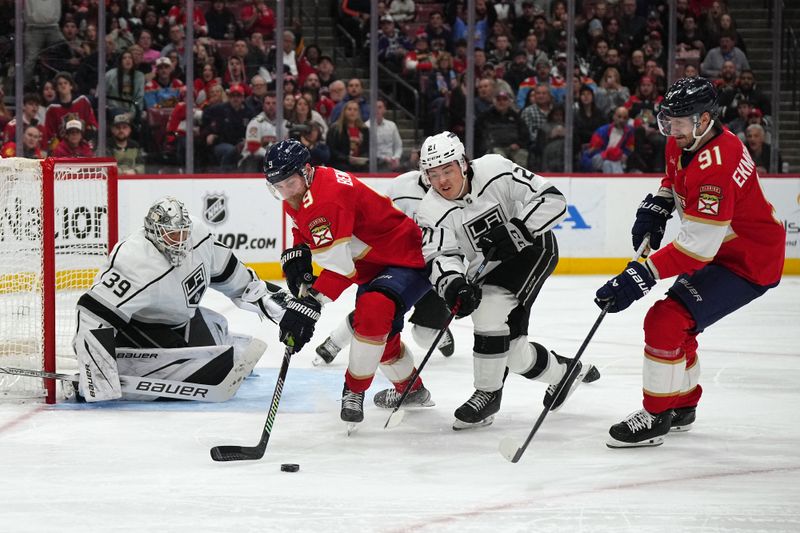 Jan 11, 2024; Sunrise, Florida, USA; Florida Panthers center Sam Bennett (9) and Los Angeles Kings defenseman Jordan Spence (21) battles for the puck during the second period at Amerant Bank Arena. Mandatory Credit: Jasen Vinlove-USA TODAY Sports