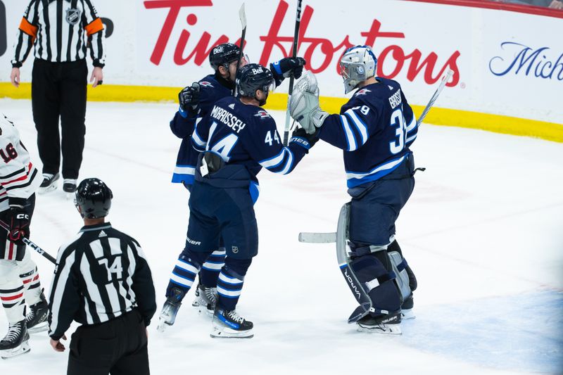 Jan 11, 2024; Winnipeg, Manitoba, CAN; Winnipeg Jets goalie Laurent Boissoit (39) is congratulated by his team mates on his win against the Chicago Blackhawks at the end of the third period at Canada Life Centre. Mandatory Credit: Terrence Lee-USA TODAY Sports