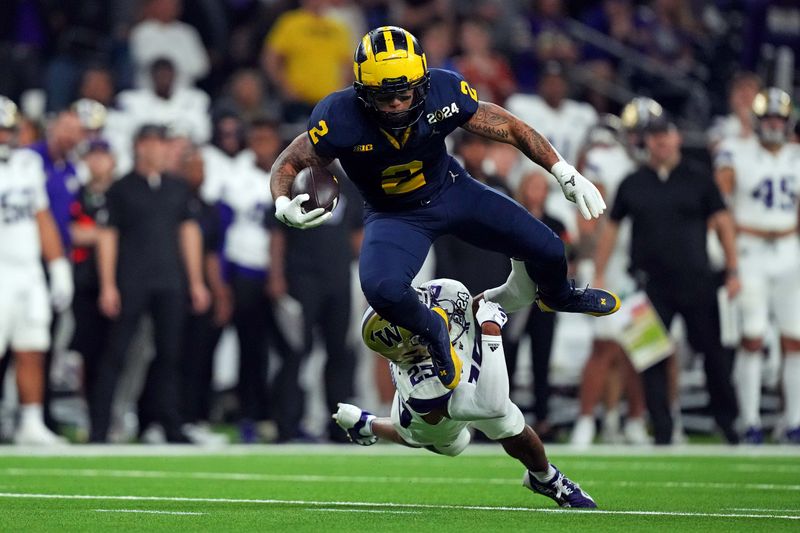 Jan 8, 2024; Houston, TX, USA; Michigan Wolverines running back Blake Corum (2) runs the ball against Washington Huskies cornerback Elijah Jackson (25) during the third quarter in the 2024 College Football Playoff national championship game at NRG Stadium. Mandatory Credit: Kirby Lee-USA TODAY Sports