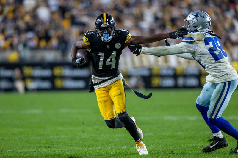 Pittsburgh Steelers wide receiver George Pickens (14) stiff arms Dallas Cowboys safety Malik Hooker (28) during an NFL football game, Sunday, Oct. 6, 2024, in Pittsburgh. (AP Photo/Matt Durisko)