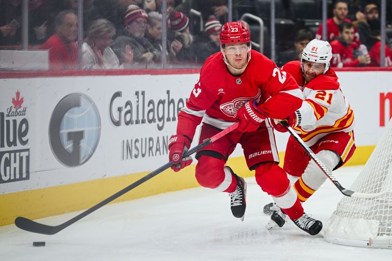 Nov 27, 2024; Detroit, Michigan, USA; Detroit Red Wings left wing Lucas Raymond (23) and Calgary Flames center Kevin Rooney (21) battle for the puck during the second period at Little Caesars Arena. Mandatory Credit: Tim Fuller-Imagn Images