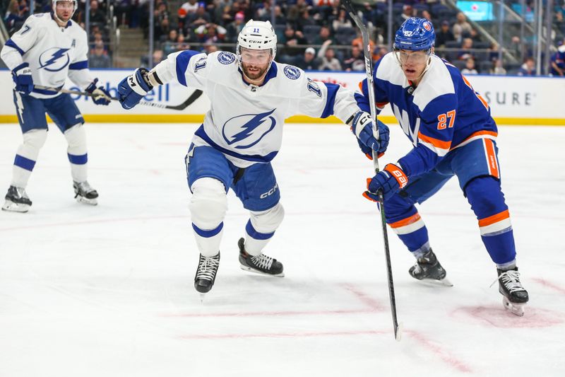 Feb 24, 2024; Elmont, New York, USA;  Tampa Bay Lightning center Luke Glendening (11) and New York Islanders left wing Anders Lee (27) chase the puck in the second period at UBS Arena. Mandatory Credit: Wendell Cruz-USA TODAY Sports