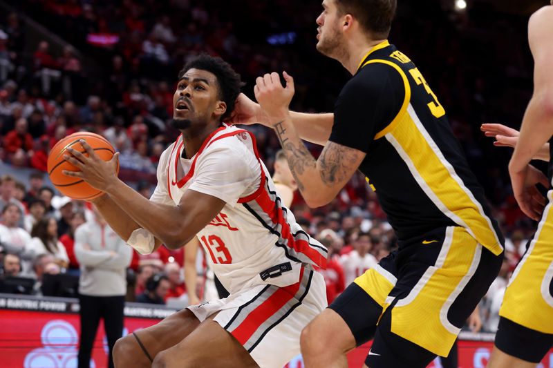 Jan 27, 2025; Columbus, Ohio, USA;  Ohio State Buckeyes forward Sean Stewart (13) takes the ball to the basket as Iowa Hawkeyes forward Owen Freeman (32) defends during the second half at Value City Arena. Mandatory Credit: Joseph Maiorana-Imagn Images