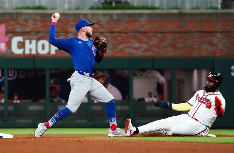 May 13, 2024; Cumberland, Georgia, USA; Chicago Cubs second base Miles Mastrobuoni (20) forces out Atlanta Braves designated hitter Marcell Ozuna (20) at second base during the seventh inning at Truist Park. Mandatory Credit: John David Mercer-USA TODAY Sports