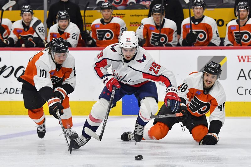 Apr 16, 2024; Philadelphia, Pennsylvania, USA; Washington Capitals center Hendrix Lapierre (29) battles for the puck Philadelphia Flyers right wing Bobby Brink (10) and  center Morgan Frost (48) during the first period at Wells Fargo Center. Mandatory Credit: Eric Hartline-USA TODAY Sports