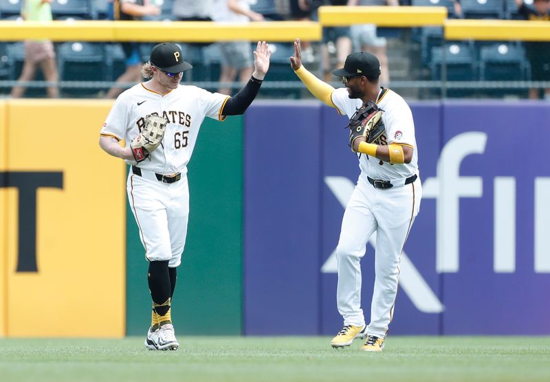 Jul 8, 2024; Pittsburgh, Pennsylvania, USA;  Pittsburgh Pirates center fielder Jack Suwinski (65) and right fielder Joshua Palacios (77) celebrate in the outfield after defeating the New York Mets at PNC Park.  The Pirates won 8-2. Mandatory Credit: Charles LeClaire-USA TODAY Sports