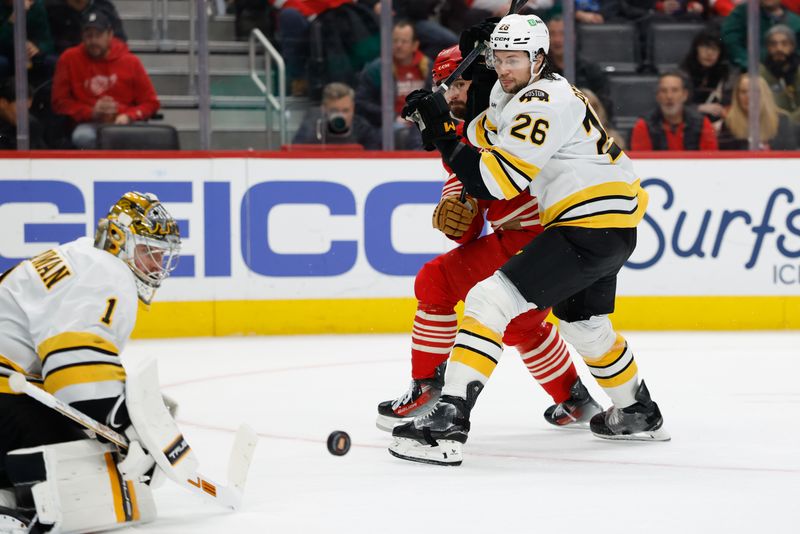 Dec 2, 2025; Detroit, Michigan, USA;  Detroit Red Wings center Dylan Larkin (71) and Boston Bruins defenseman Andrew Peeke (26) battle for the puck in the second period at Little Caesars Arena. Mandatory Credit: Rick Osentoski-Imagn Images