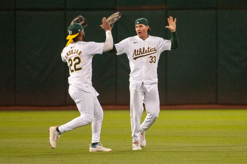 Jun 18, 2024; Oakland, California, USA; Oakland Athletics outfielder Miguel Andujar (22) and outfielder JJ Bleday (33) celebrate after defeating the Kansas City Royals at Oakland-Alameda County Coliseum. Mandatory Credit: Ed Szczepanski-USA TODAY Sports