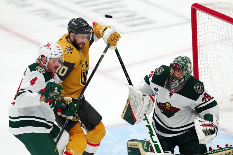 Apr 12, 2024; Las Vegas, Nevada, USA; Minnesota Wild goaltender Marc-Andre Fleury (29) defends his net as an errant shot goes wide of Minnesota Wild defenseman Jon Merrill (4) and Vegas Golden Knights center Nicolas Roy (10) during the third period at T-Mobile Arena. Mandatory Credit: Stephen R. Sylvanie-USA TODAY Sports