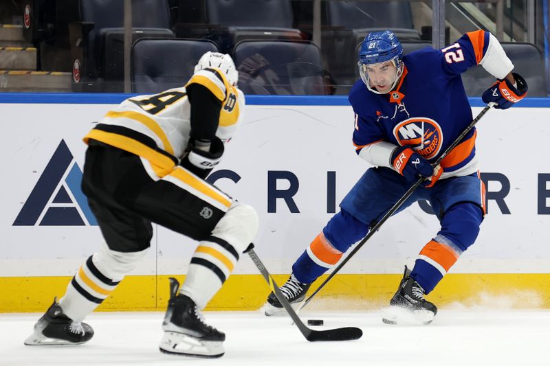 Nov 5, 2024; Elmont, New York, USA; New York Islanders center Kyle Palmieri (21) skates with the puck against Pittsburgh Penguins defenseman Marcus Pettersson (28) during overtime at UBS Arena. Mandatory Credit: Brad Penner-Imagn Images