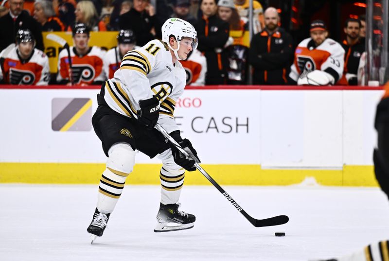 Jan 27, 2024; Philadelphia, Pennsylvania, USA; Boston Bruins center Trent Frederic (11) controls the puck against the Philadelphia Flyers in the third period at Wells Fargo Center. Mandatory Credit: Kyle Ross-USA TODAY Sports