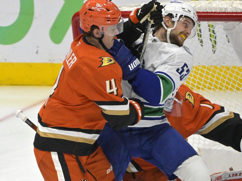 Nov 5, 2024; Anaheim, California, USA; Anaheim Ducks defenseman Cam Fowler (4) and Vancouver Canucks center Teddy Blueger (53) battle for position on the ice in the second period at Honda Center. Mandatory Credit: Jayne Kamin-Oncea-Imagn Images