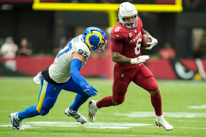 Arizona Cardinals running back James Conner (6) runs near Los Angeles Rams linebacker Michael Hoecht (97) during the first half of an NFL football game, Sunday, Sept. 15, 2024, in Glendale, Ariz. (AP Photo/Ross D. Franklin)