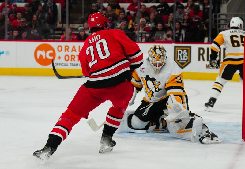 Jan 13, 2024; Raleigh, North Carolina, USA;  Pittsburgh Penguins goaltender Tristan Jarry (35) stops the shot by Carolina Hurricanes center Sebastian Aho (20) during the first period at PNC Arena. Mandatory Credit: James Guillory-USA TODAY Sports