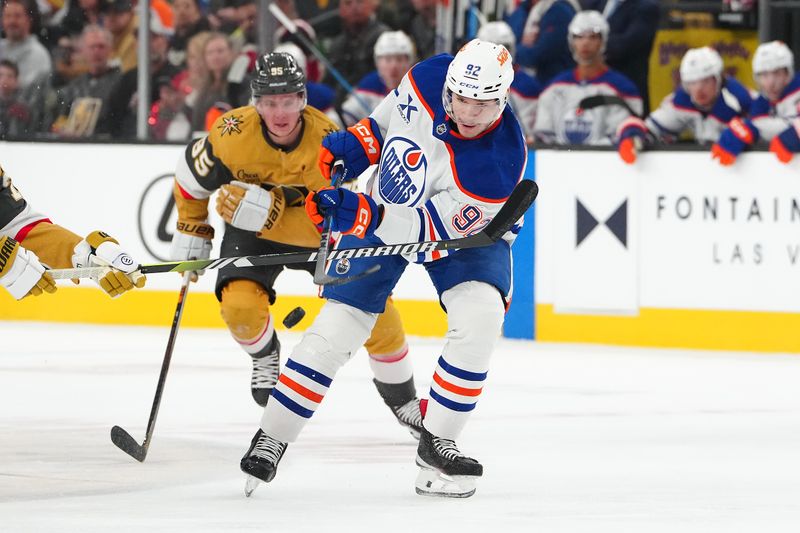 Apr 1, 2025; Las Vegas, Nevada, USA; Edmonton Oilers right wing Vasily Podkolzin (92) attempts to dump the puck into the Vegas Golden Knights zone during the first period at T-Mobile Arena. Mandatory Credit: Stephen R. Sylvanie-Imagn Images