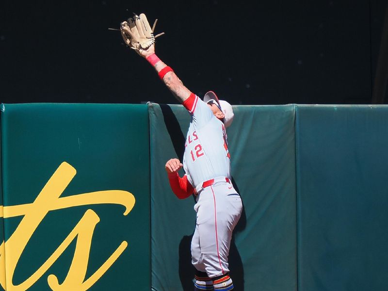 Jul 4, 2024; Oakland, California, USA; Los Angeles Angels center fielder Kevin Pillar (12) jumps up but is unable to catch the ball for an Oakland Athletics home run during the eighth inning at Oakland-Alameda County Coliseum. Mandatory Credit: Kelley L Cox-USA TODAY Sports