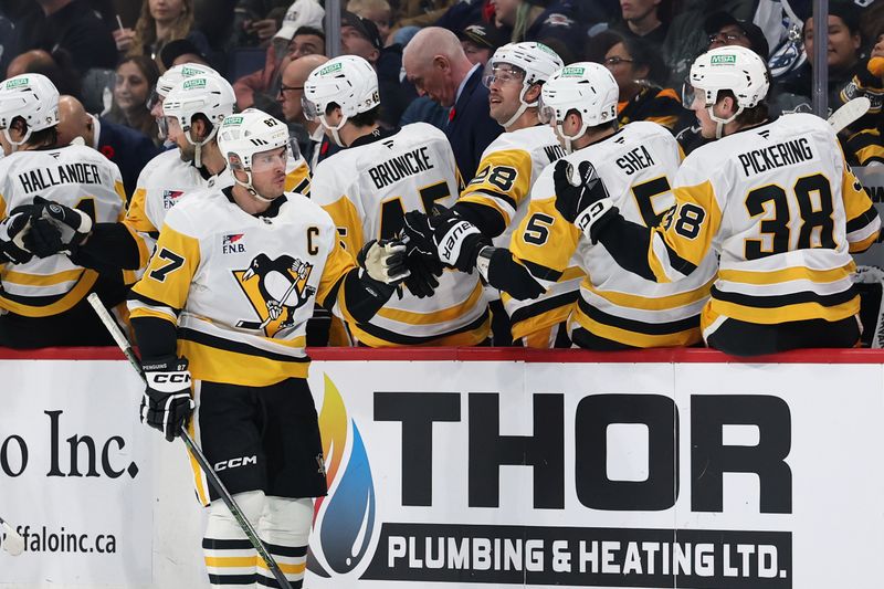 Nov 1, 2025; Winnipeg, Manitoba, CAN; Pittsburgh Penguins center Sidney Crosby (87) shakes hands with his teammates on the bench after scoring a goal against the Winnipeg Jets in the second period at Canada Life Centre. Mandatory Credit: James Carey Lauder-Imagn Images