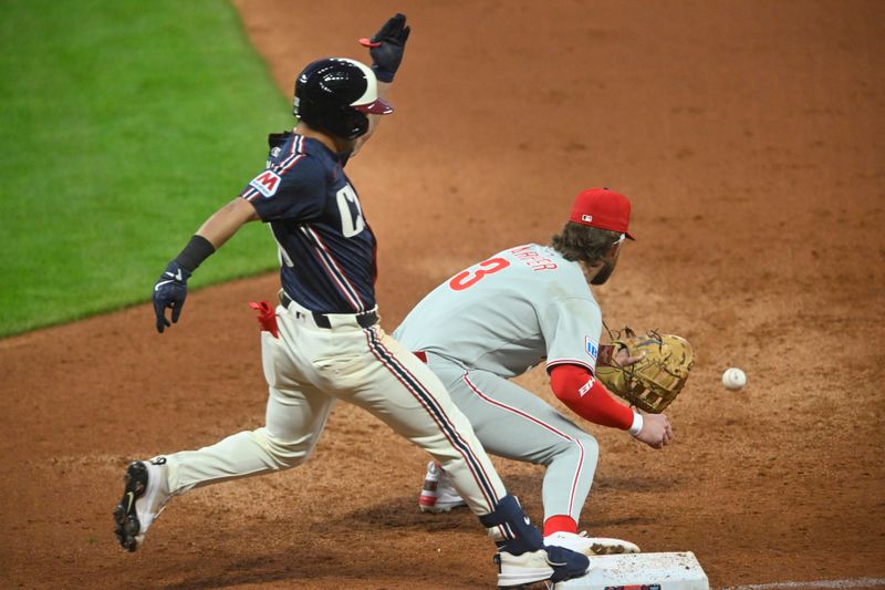 May 9, 2025; Cleveland, Ohio, USA; Cleveland Guardians left fielder Steven Kwan (38) reaches base safely beside Philadelphia Phillies first baseman Bryce Harper (3) on an infield single in the fifth inning at Progressive Field. Mandatory Credit: David Richard-Imagn Images