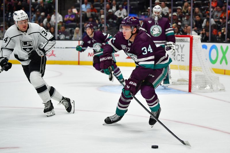 Nov 24, 2023; Anaheim, California, USA;Anaheim Ducks defenseman Pavel Mintyukov (34) moves the puck against Los Angeles Kings right wing Arthur Kaliyev (34) during the first period at Honda Center. Mandatory Credit: Gary A. Vasquez-USA TODAY Sports