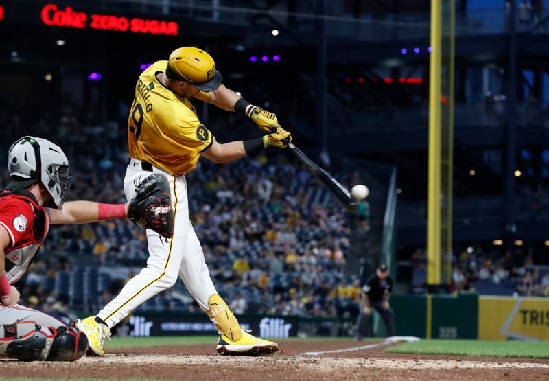 Aug 23, 2024; Pittsburgh, Pennsylvania, USA;  Pittsburgh Pirates third baseman Jared Triolo (19) hits an RBI single against the Cincinnati Reds during the fifth inning at PNC Park. Mandatory Credit: Charles LeClaire-USA TODAY Sports