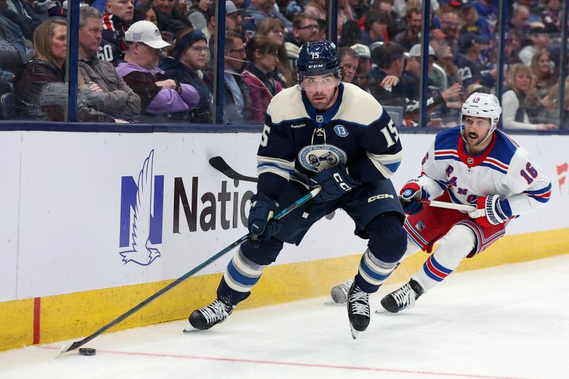 Mar 15, 2025; Columbus, Ohio, USA;  Columbus Blue Jackets defenseman Dante Fabbro (15) controls the puck as New York Rangers center Vincent Trocheck (16) defends  during the third period at Nationwide Arena. Mandatory Credit: Joseph Maiorana-Imagn Images