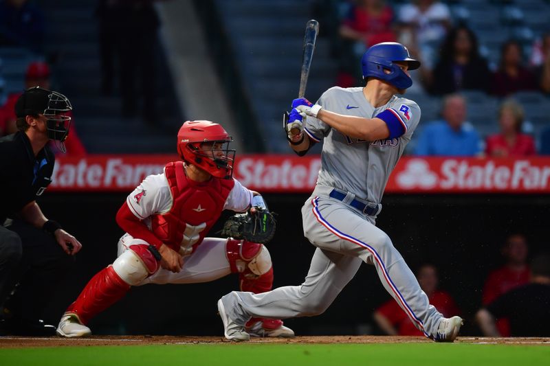 Sep 26, 2023; Anaheim, California, USA; Texas Rangers shortstop Corey Seager (5) hits a single against the Los Angeles Angels during the first inning at Angel Stadium. Mandatory Credit: Gary A. Vasquez-USA TODAY Sports