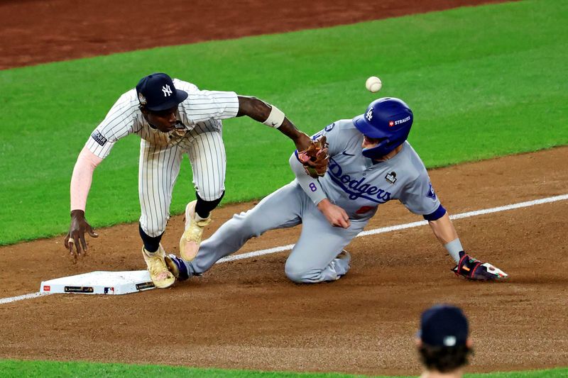 Oct 30, 2024; Bronx, New York, USA; Los Angeles Dodgers third baseman Enrique Hernandez (8) reaches third base after an error by New York Yankees third baseman Jazz Chisholm Jr. (13) during the fifth inning during game five of the 2024 MLB World Series at Yankee Stadium. Mandatory Credit: James Lang-Imagn Images