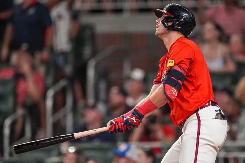 Aug 2, 2024; Cumberland, Georgia, USA; Atlanta Braves third baseman Austin Riley (27) hits a double against the Miami Marlins during the eighth inning at Truist Park. Mandatory Credit: Dale Zanine-USA TODAY Sports