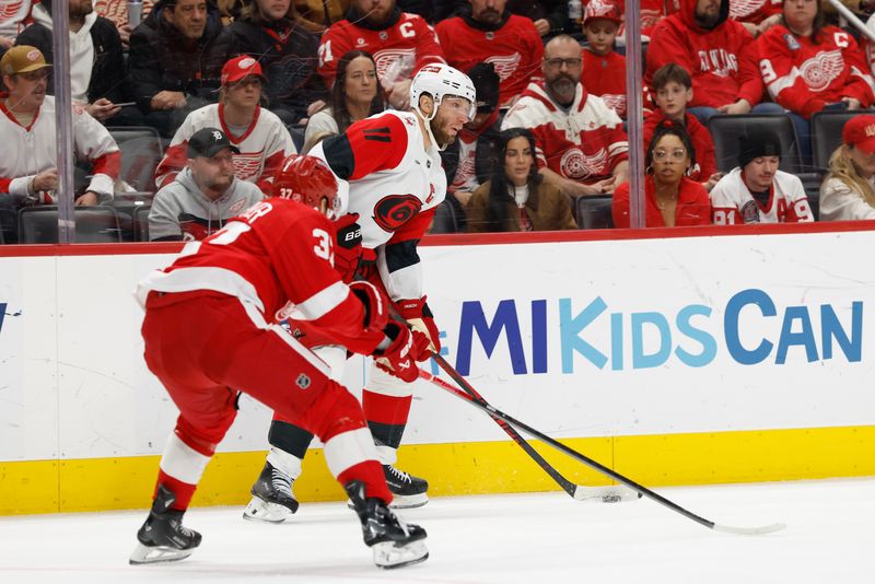 Jan 12, 2026; Detroit, Michigan, USA;  Carolina Hurricanes center Jordan Staal (11) skates with the puck defended by Detroit Red Wings left wing J.T. Compher (37) in the third period at Little Caesars Arena. Mandatory Credit: Rick Osentoski-Imagn Images