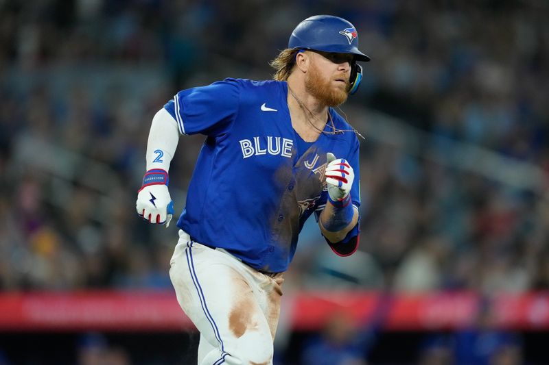 Apr 14, 2024; Toronto, Ontario, CAN; Toronto Blue Jays designated hitter Justin Turner (2) runs to first base on his one run double against the Colorado Rockies during the third inning at Rogers Centre. Mandatory Credit: John E. Sokolowski-USA TODAY Sports