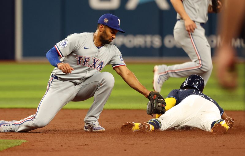 Apr 2, 2024; St. Petersburg, Florida, USA; Tampa Bay Rays shortstop Jose Caballero (7) steals second base as Texas Rangers second baseman Marcus Semien (2) attempted to tag him out during the third inning at Tropicana Field. Mandatory Credit: Kim Klement Neitzel-USA TODAY Sports