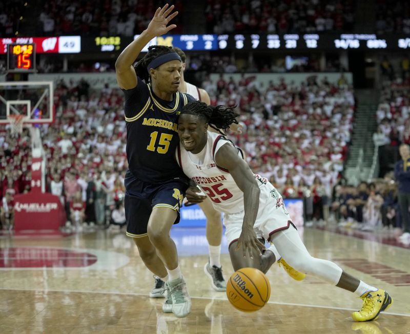 Dec 3, 2024; Madison, Wisconsin, USA; Wisconsin guard John Blackwell (25) runs into Michigan guard Rubin Jones (15) during the second half of their game Tuesday, December 3, 2024 at the Kohl Center in Madison, Wisconsin. Michigan beat Wisconsin 67-64.  Mandatory Credit: Mark Hoffman/USA TODAY Network via Imagn Images 