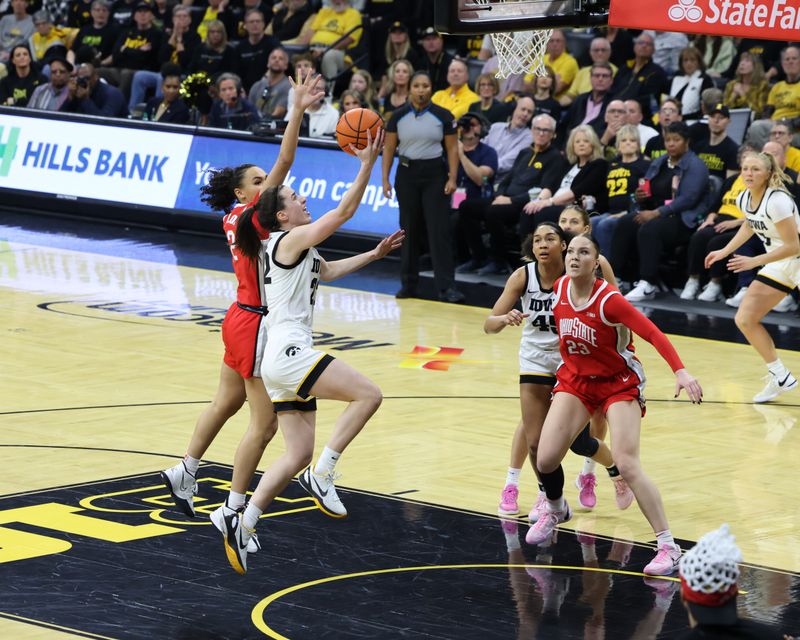 Mar 3, 2024; Iowa City, Iowa, USA; Iowa Hawkeyes guard Caitlin Clark (22) drives past Ohio State Buckeyes guard Taylor Thierry (2) during the first half at Carver-Hawkeye Arena. Mandatory Credit: Reese Strickland-USA TODAY Sports