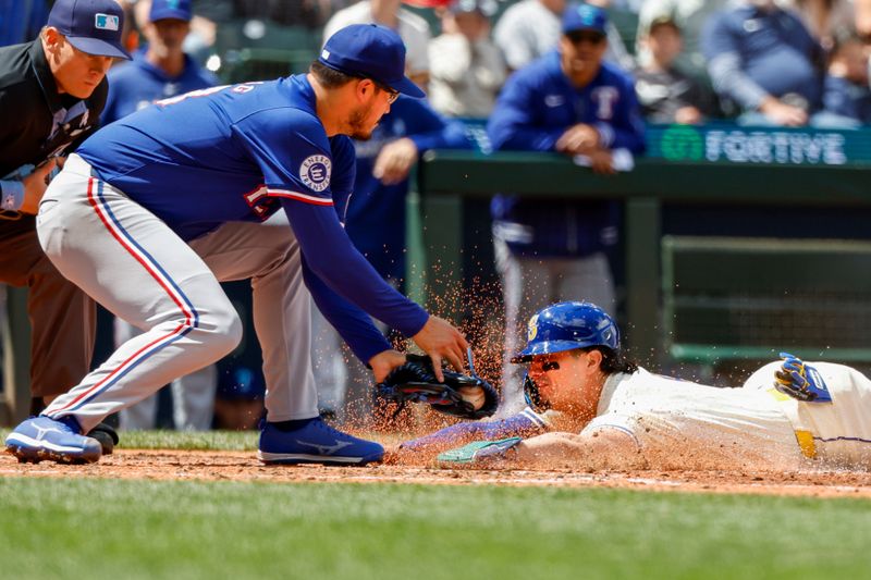 Jun 16, 2024; Seattle, Washington, USA; Seattle Mariners third baseman Josh Rojas (4) slides to score a run on a wild pitch by Texas Rangers starting pitcher Dane Dunning (33) during the fifth inning at T-Mobile Park. Mandatory Credit: Joe Nicholson-USA TODAY Sports