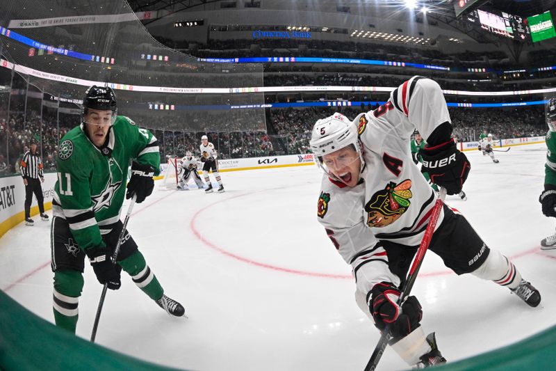 Nov 7, 2024; Dallas, Texas, USA; Dallas Stars center Logan Stankoven (11) and Chicago Blackhawks defenseman Connor Murphy (5) chase the puck during the second period at the American Airlines Center. Mandatory Credit: Jerome Miron-Imagn Images