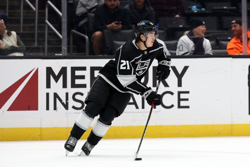 Nov 11, 2023; Los Angeles, California, USA;  Los Angeles Kings defenseman Jordan Spence (21) controls the puck during the third period against the Philadelphia Flyers at Crypto.com Arena. Mandatory Credit: Kiyoshi Mio-USA TODAY Sports