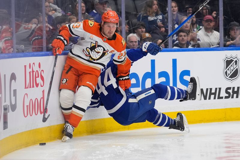 Mar 12, 2026; Toronto, Ontario, CAN; Anaheim Ducks forward Mason McTavish (23) avoids a check by Toronto Maple Leafs defenseman Morgan Rielly (44) during the second period at Scotiabank Arena. Mandatory Credit: John E. Sokolowski-Imagn Images