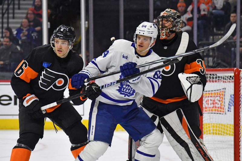 Mar 19, 2024; Philadelphia, Pennsylvania, USA; Toronto Maple Leafs center David Kampf (64) battles for position with Philadelphia Flyers defenseman Travis Sanheim (6) and goaltender Samuel Ersson (33) during the second period at Wells Fargo Center. Mandatory Credit: Eric Hartline-USA TODAY Sports