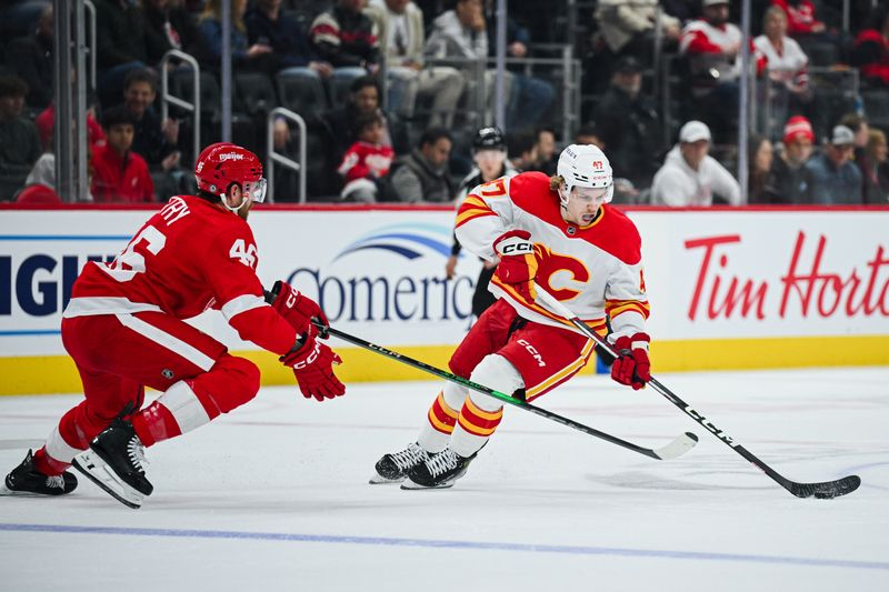 Nov 27, 2024; Detroit, Michigan, USA; Calgary Flames center Connor Zary (47) brings the puck up ice against Detroit Red Wings defenseman Jeff Petry (46) during the second period at Little Caesars Arena. Mandatory Credit: Tim Fuller-Imagn Images