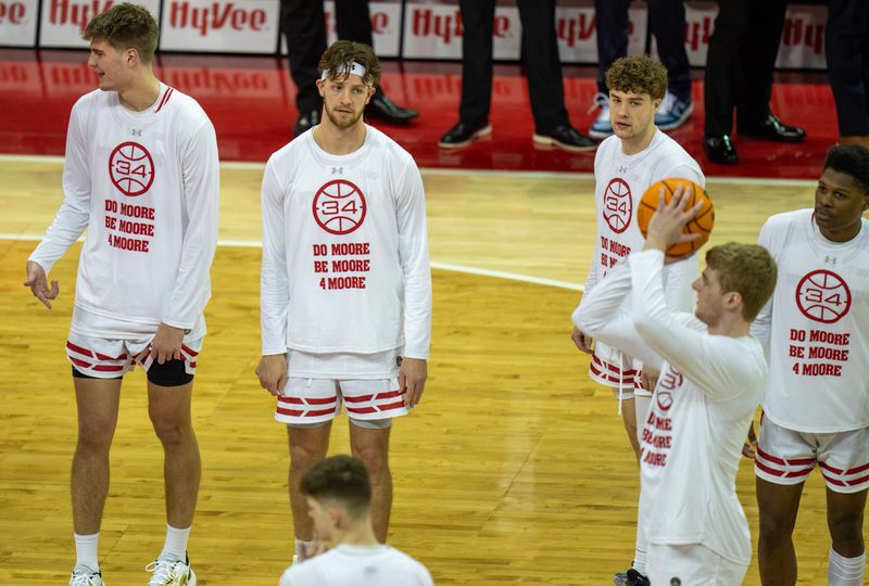 Mar 2, 2024; Madison, WI, USA; Wisconsin players wear shirts honoring former assistant coach Howard Moore before their  game against Illinois, Saturday, March 2, 2024 at the Kohl Center in Madison, Wisconsin. Moore suffered severe burns in horrific automobile accident on Memorial Day weekend in 2020, resulting in the deaths of his wife and daughter. His son, Jerrell, suffered minor injuries.
 Mandatory Credit: Mark Hoffman-USA TODAY Sports