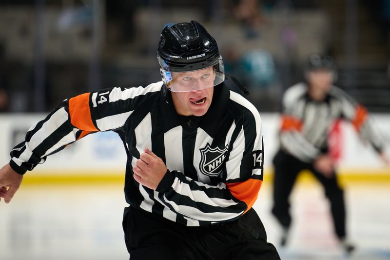 Sep 21, 2025; San Jose, California, USA; Referee Trevor Hanson (14) skates before the third period of a game between the San Jose Sharks and the Vegas Golden Knights at SAP Center at San Jose. Mandatory Credit: Robert Edwards-Imagn Images