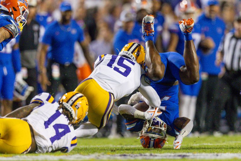 Nov 11, 2023; Baton Rouge, Louisiana, USA;  Florida Gators running back Trevor Etienne (7) is tackled by Florida Gators linebacker Derek Wingo (15) during the first half at Tiger Stadium. Mandatory Credit: Stephen Lew-USA TODAY Sports