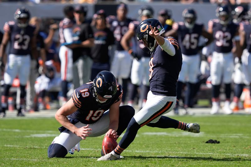 Chicago Bears place-kicker Cairo Santos (8) kicks a 33-yard field goal out of the hold of Tory Taylor (19) during the second half of an NFL football game against the Carolina Panthers Sunday, Oct. 6, 2024, in Chicago. (AP Photo/Charles Rex Arbogast)